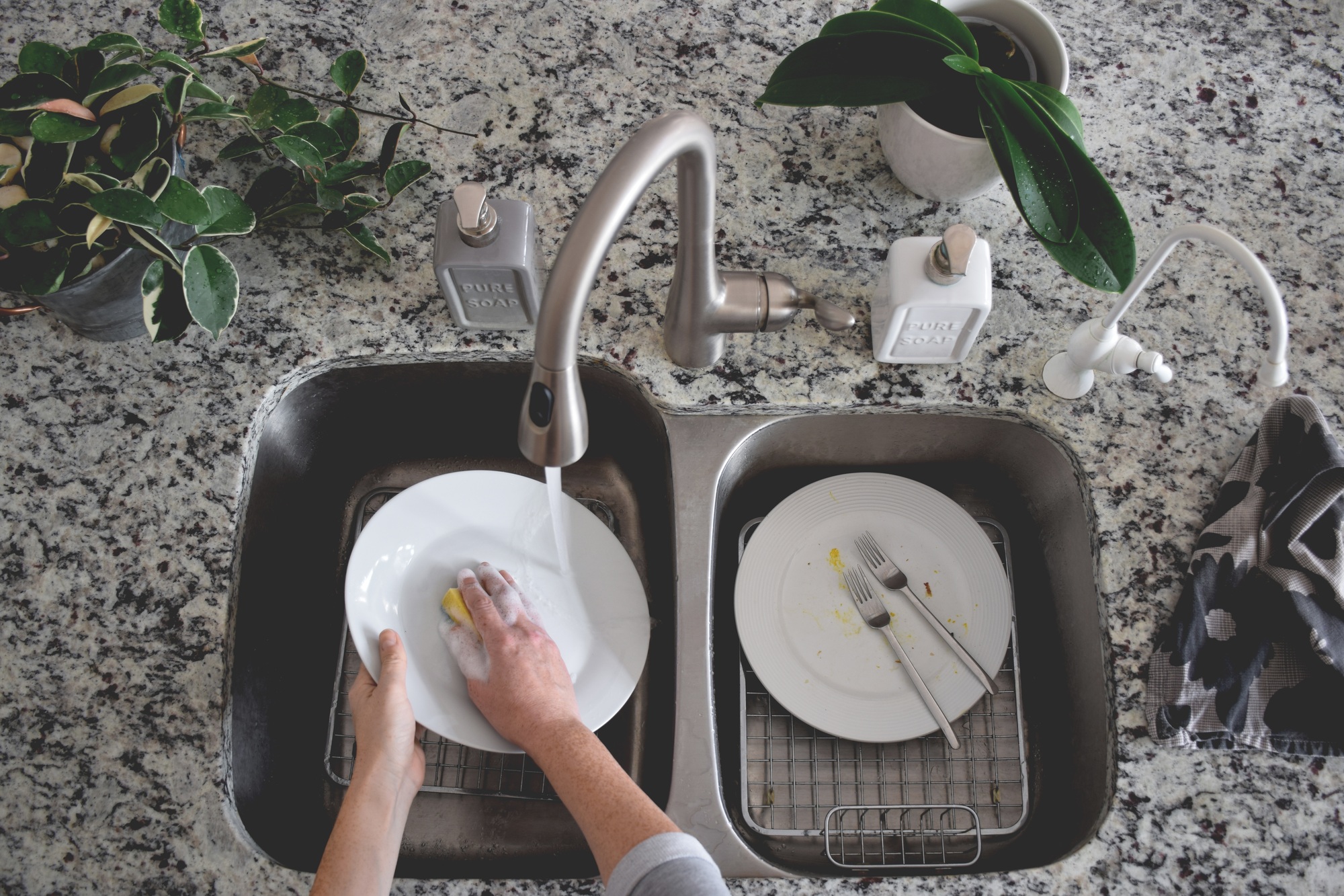 Top view of woman washing dishes in the kitchen sink